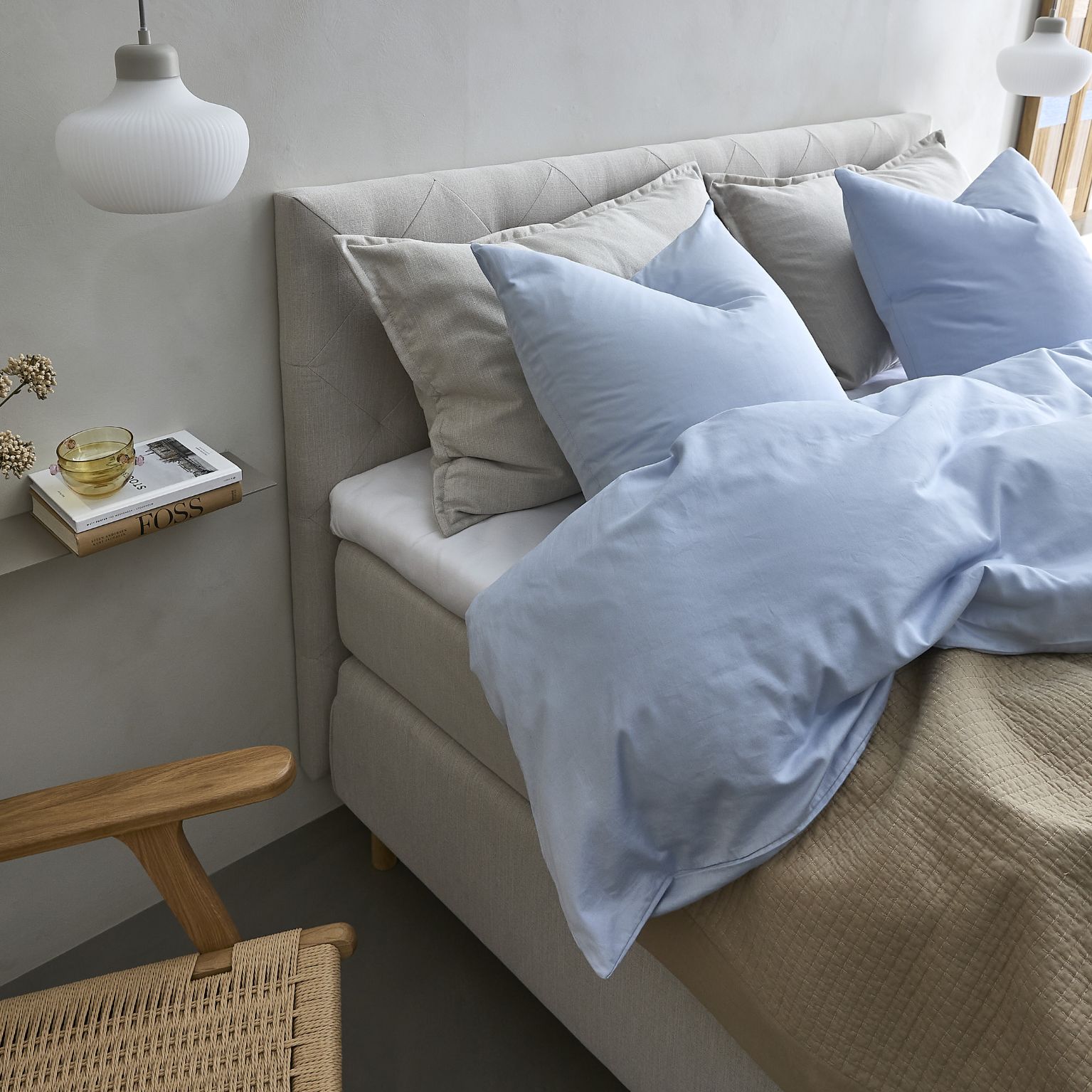 Nærbild av bäddad säng i blått och grått.