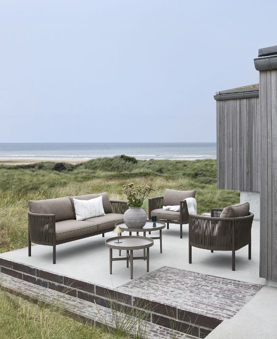 Loungeområde på träterrass med loungeset i grå toner