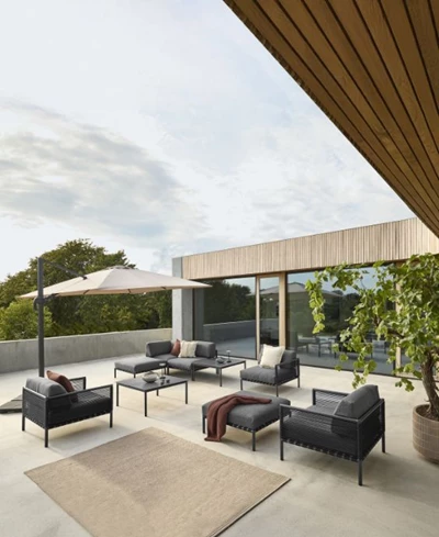Modern terrass med loungemöbler i mörk stomme och grå dynor