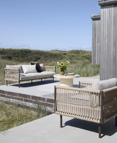 Loungemöbler på terrass med sanddyner i bakgrunden