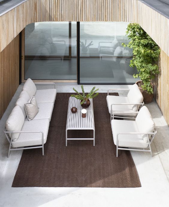 Ljusa loungemöbler på röd matta