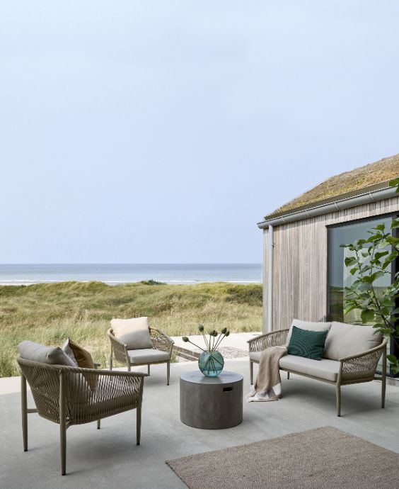 Mysig uteplats med loungesoffa och två loungestolar i grått