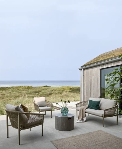 Mysig uteplats med loungesoffa och två loungestolar i grått