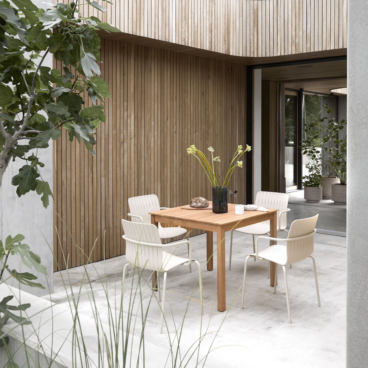 Mysigt terrassområde med träbord och trädgårdsstolar