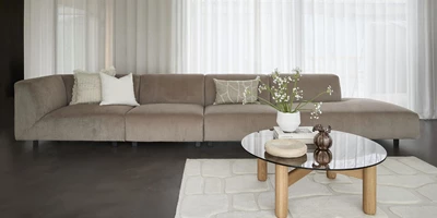 Minimalistiskt vardagsrum i grå nyanser med open end-soffa och soffbord