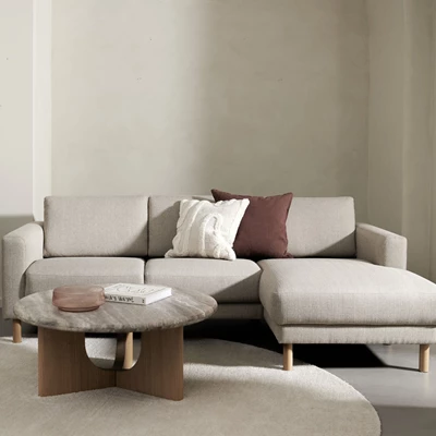Schäslongsoffa i ljusbeige tillsammans med soffbord
