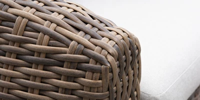 Närbild av armstöd i polyrattan