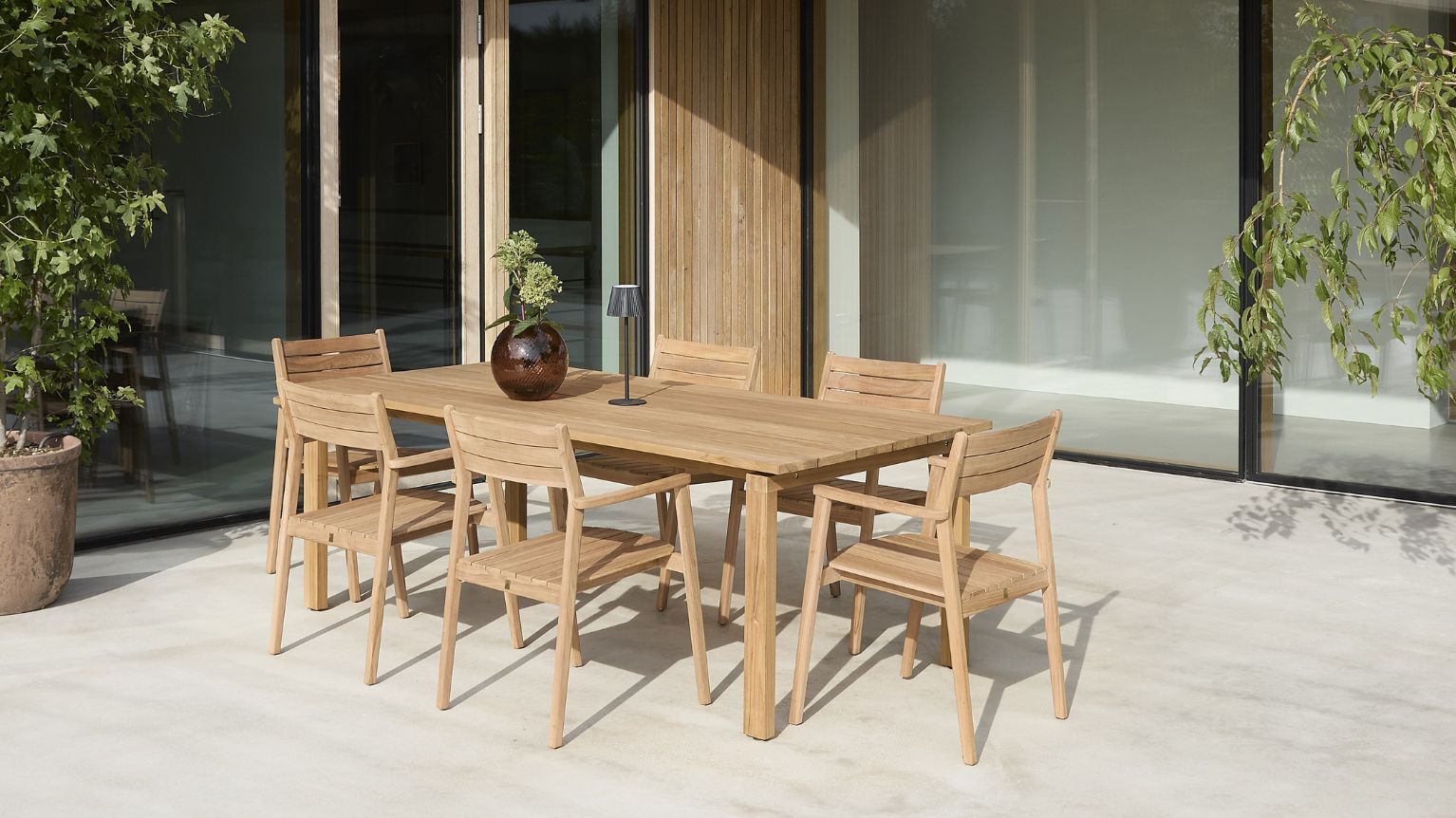 Trädgårdsbord och stolar i trä på terrass