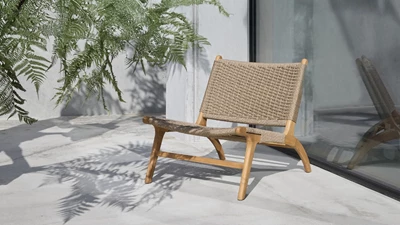 Loungefåtölj i flätat material stående på en terrass.