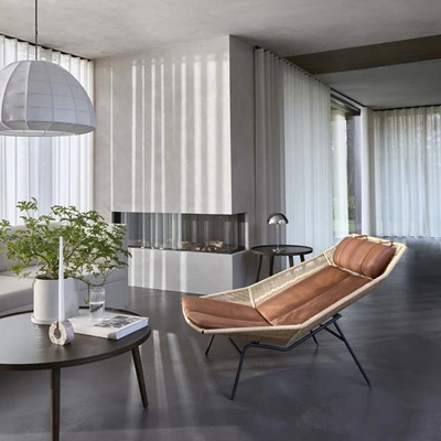 Mysigt vardagsrum med en tillbakalutad fåtölj i bruna toner