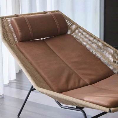 Närbild av fåtölj med brunt lädersäte.