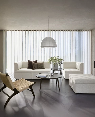 Ljust och nordiskt vardagsrum med vit soffa, fåtölj och soffbord.