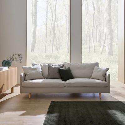 2-sitssoffa i ljust tyg placerad framför ett stort panoramafönster.