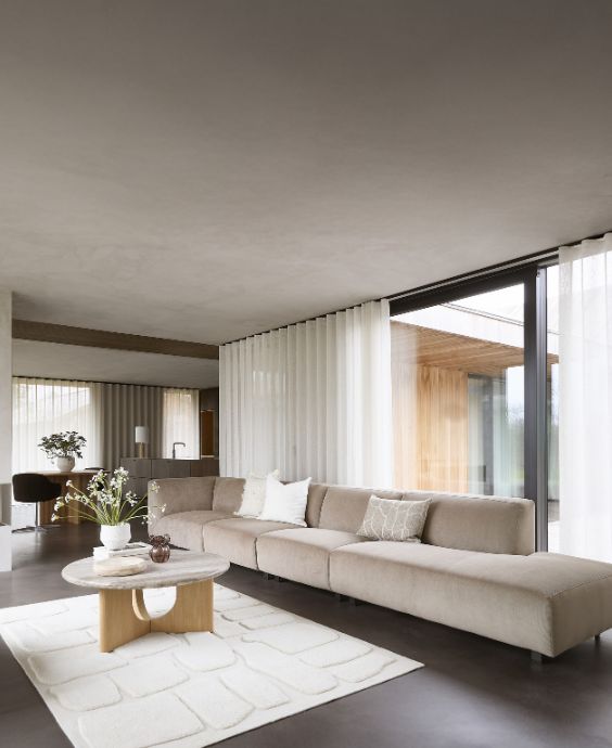 Minimalistiskt vardagsrum med en beige soffa med open end.