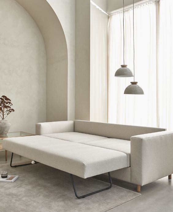 Utdragen bäddsoffa i ljus färg.