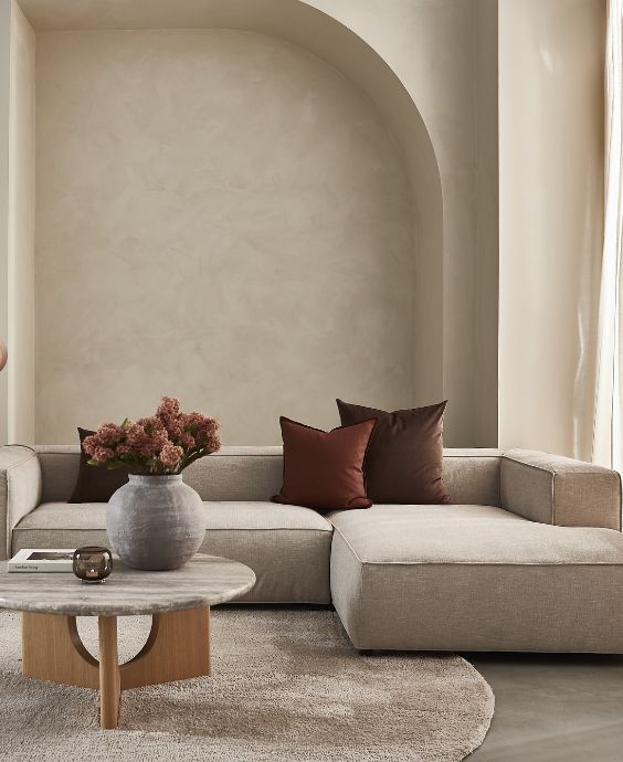 Beigefärgad modulsoffa i ett beige vardagsrum.