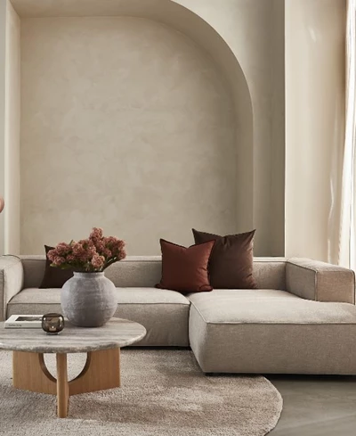 Beigefärgad modulsoffa i ett beige vardagsrum.