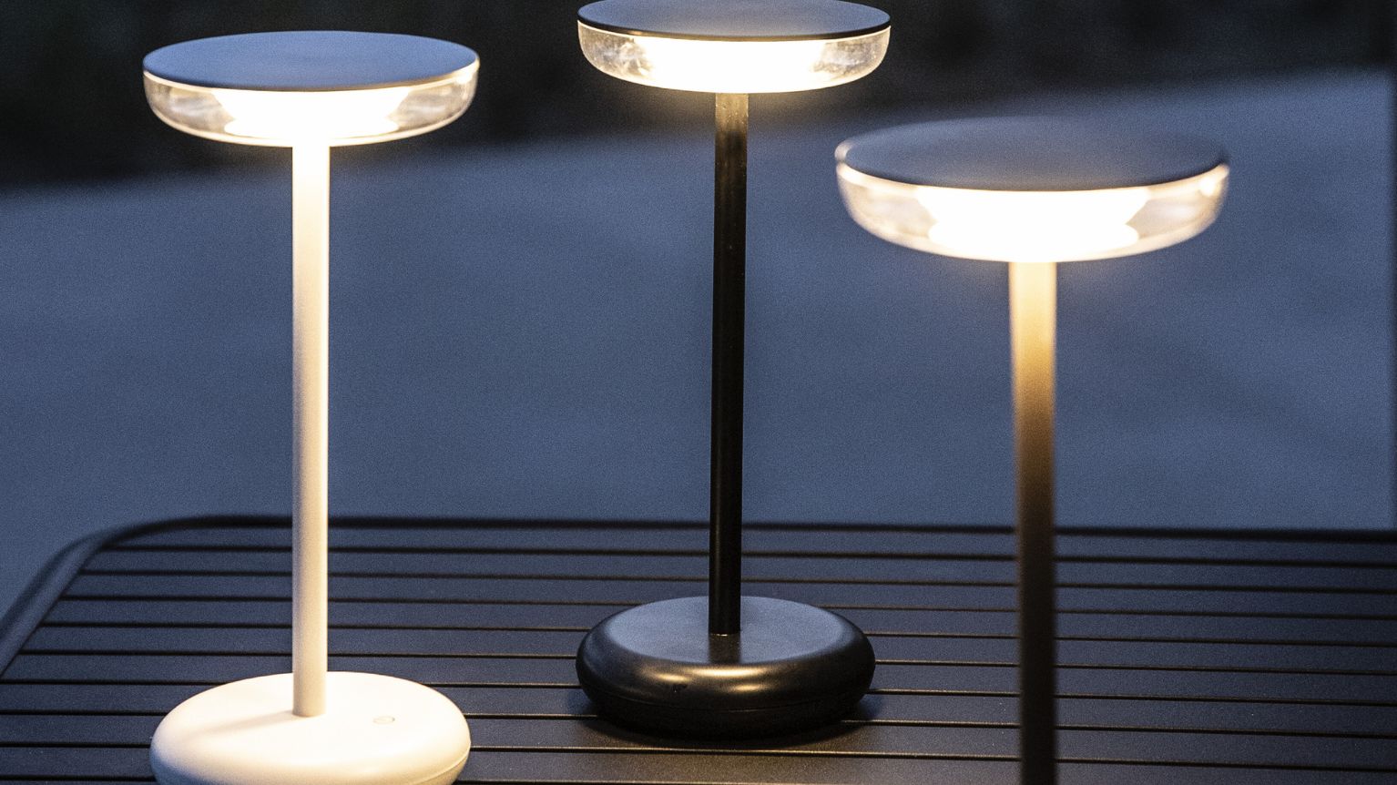 3 bordlampor med tända ljus