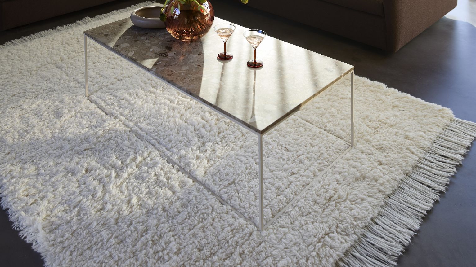 Vitt och fluffigt täcke under soffbord med glasskiva