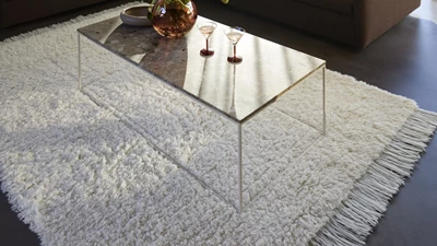 Vitt och fluffigt täcke under soffbord med glasskiva