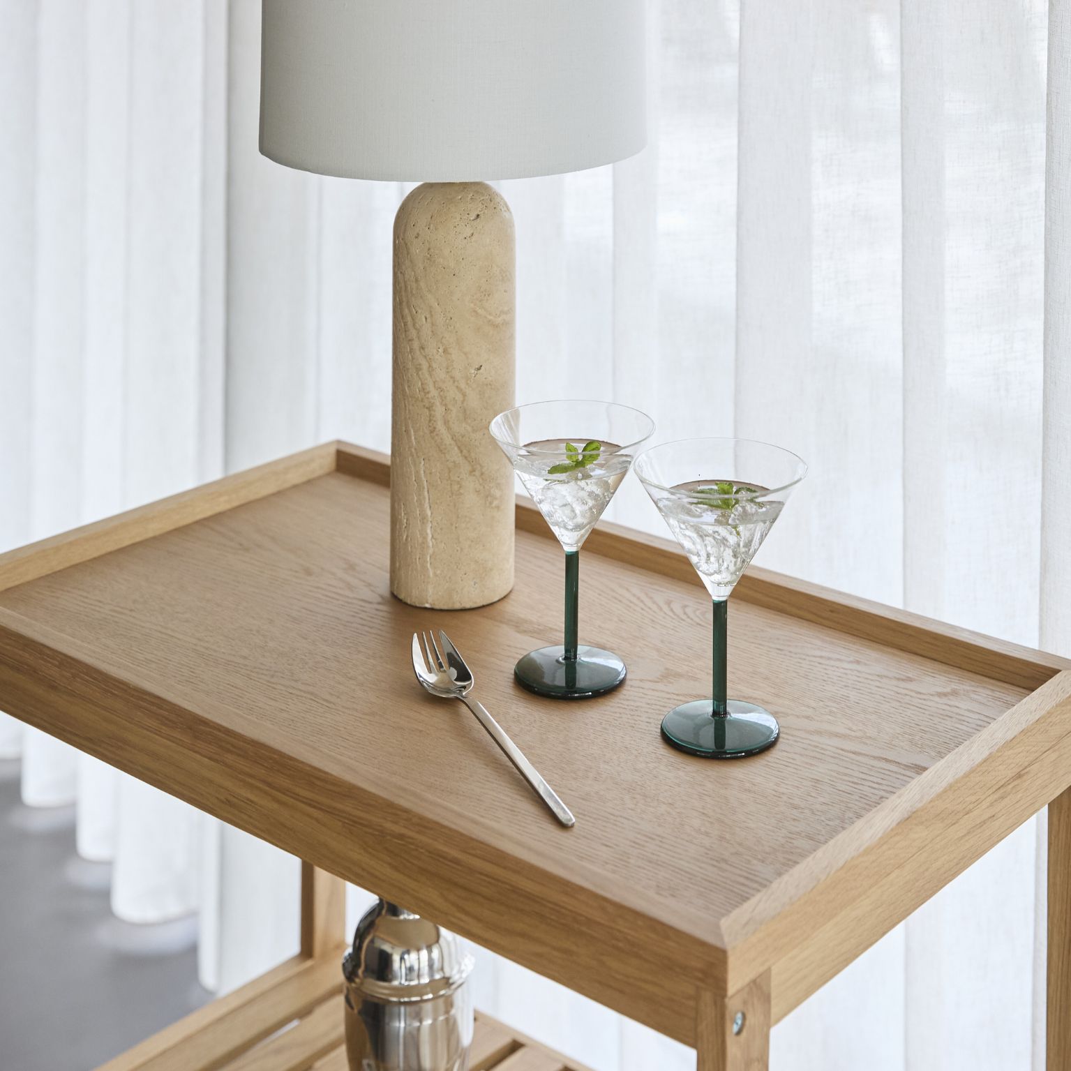 Serveringsvagn i trä med dricksglas och lampa ovanpå