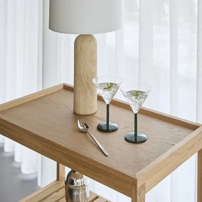 Gullveig.jpg Serveringsvagn i trä med dricksglas och lampa ovanpå