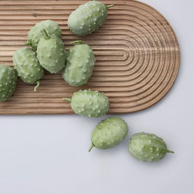 Rigmor.jpg Räfflad skärbräda i trä med gröna frukter ovanpå