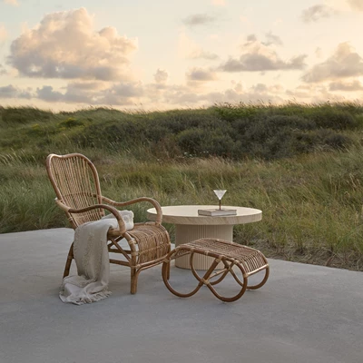 Fåtölj med tillhörande pall i naturrattan.