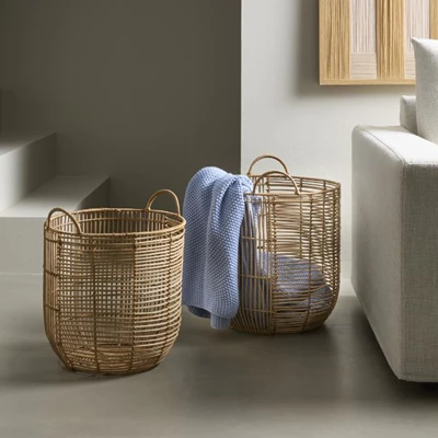 2 flätade korgar stående på grått golv