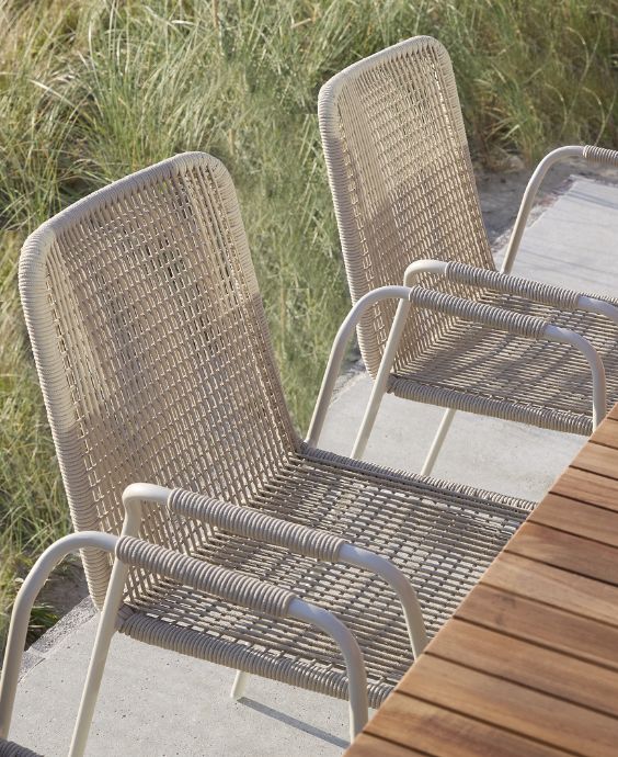 Gråa trädgårdsstolar stående vid bord.