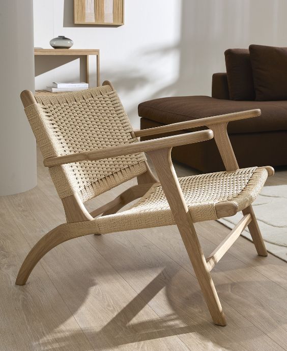 Fåtölj i ljust trä med papperssnörflätning.