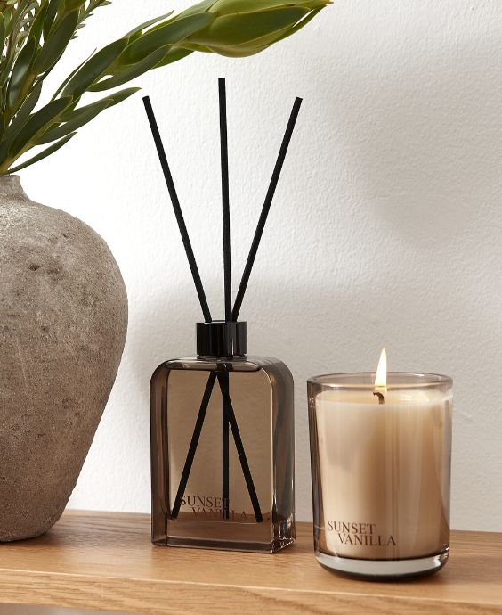 Doftspridare och doftljus stående på trähylla