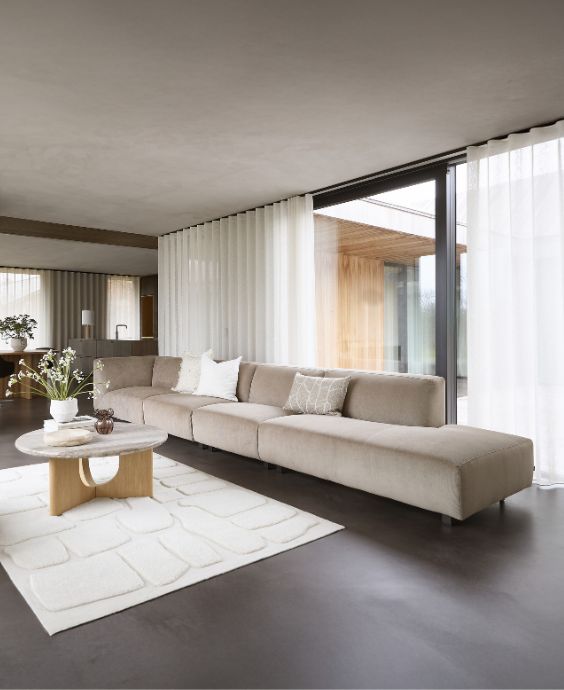 Minimalistiskt vardagsrum med grå soffa med öppen ände.