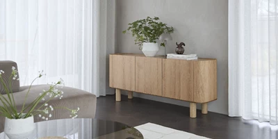 Minimalistiskt vardagsrum med betongolv och ljus träsideboard