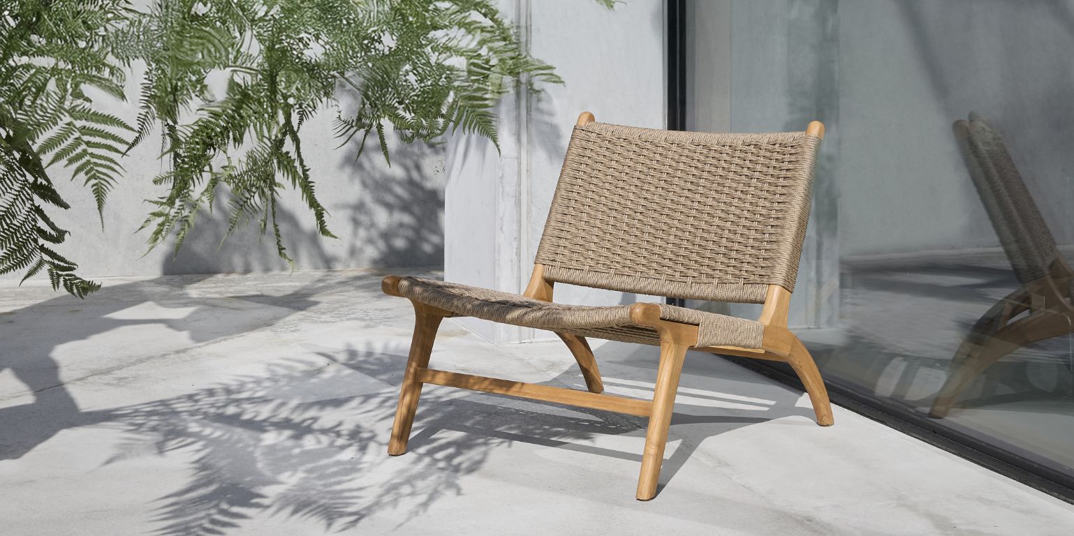 Utomhus loungestol i trä med sits och ryggstöd i flätning.