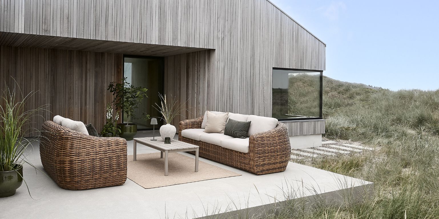 Utomhus terrassmiljö med trädgårdsmöbler i konstrotting.