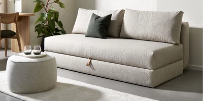 Innovation.jpg Lys sovesofa med puf i hvid som bord