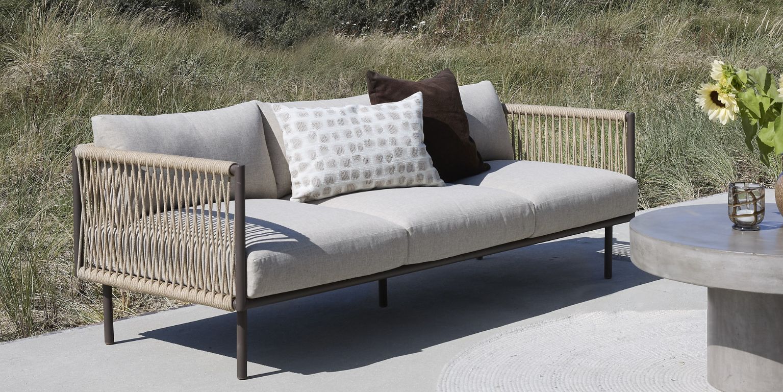 Loungesofa med grå hynde og flettet reb i siderne