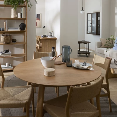 Runt matbord i trä med matstolar och massor av mysiga detaljer