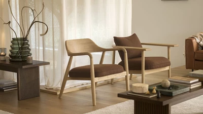 lystra.jpg Två fåtöljer i trä med stoppade, röda sitsar. Båda står i ett vardagsrum med trägolv.