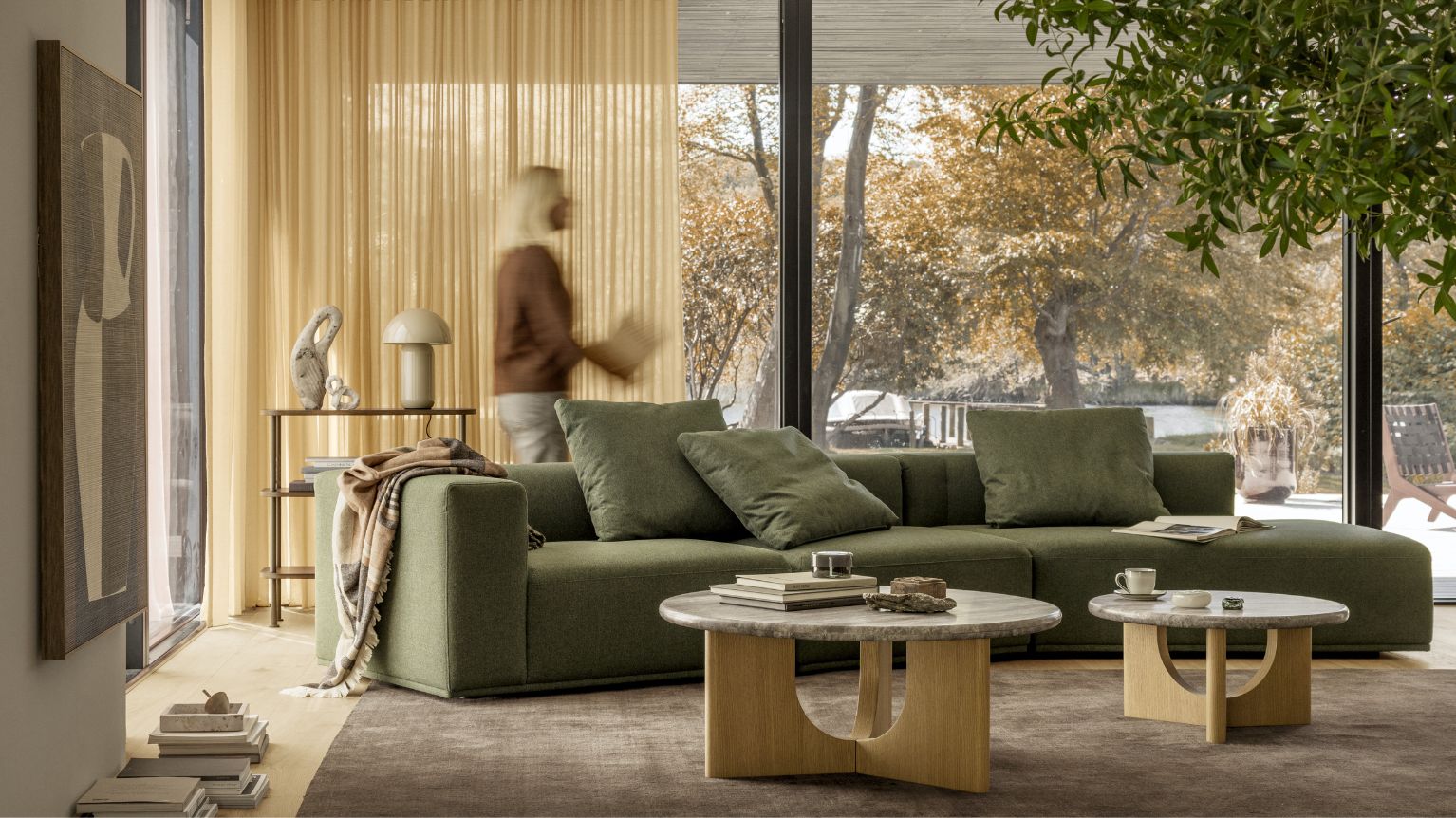 Mysigt och livligt vardagsrum med två soffbord, en grön soffa med open end samt diverse mysiga detaljer.