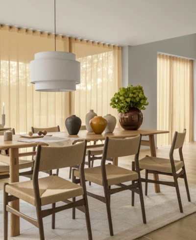 Matsal med matbord i trä samt stolar med mörkt trästativ och sitsar och ryggar i flätning.