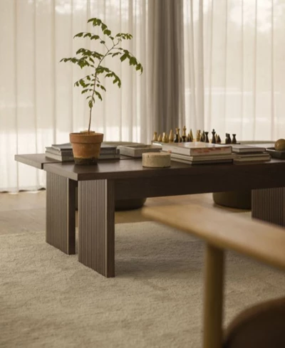 Två soffbord i mörkt trä stående bredvid varandra. Ovanpå står bland annat ett schackspel.