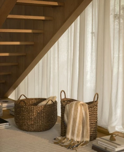 Två förvaringskorgar under trappa.