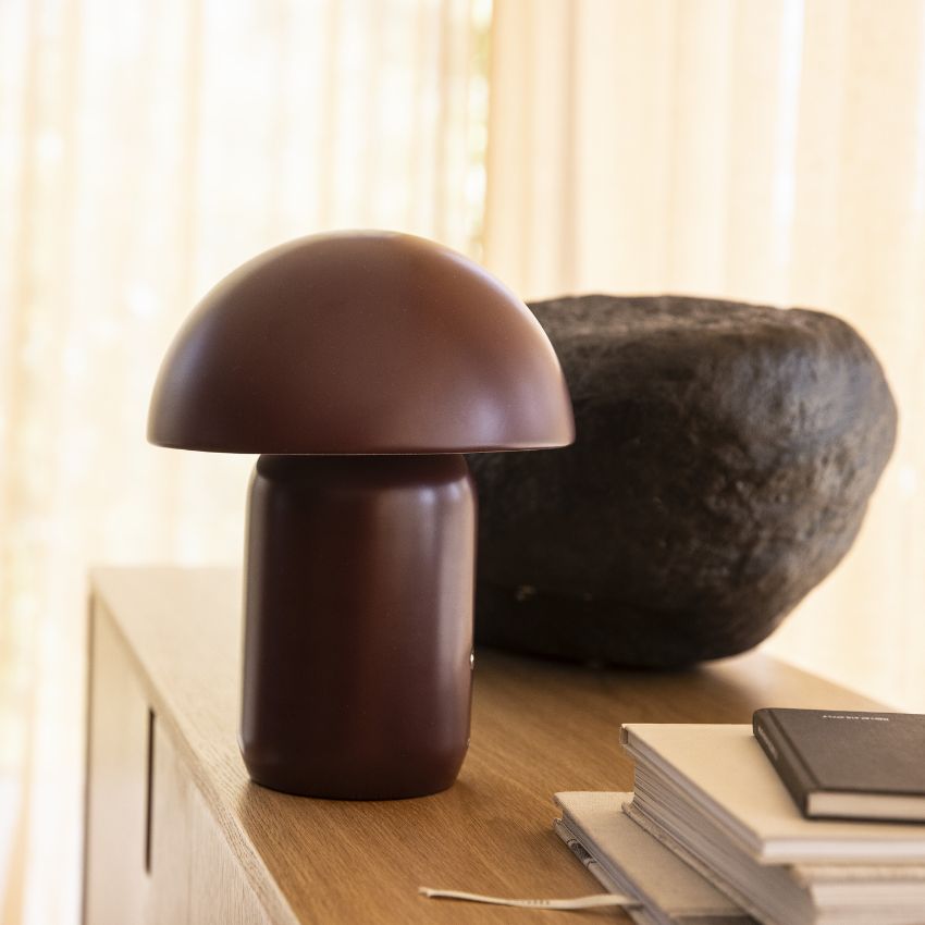 Rödaktig bordslampa stående på träyta