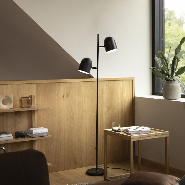 Svart golvlampa stående på trägolv