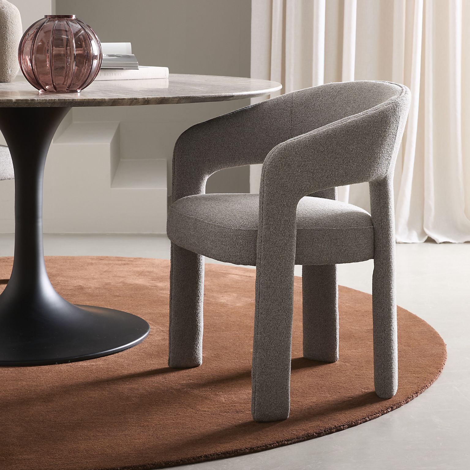 Grå stoppad matstol vid runt matbord