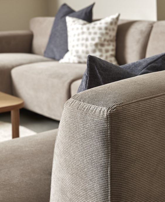 Närbild av armstöd på sandfärgad soffa