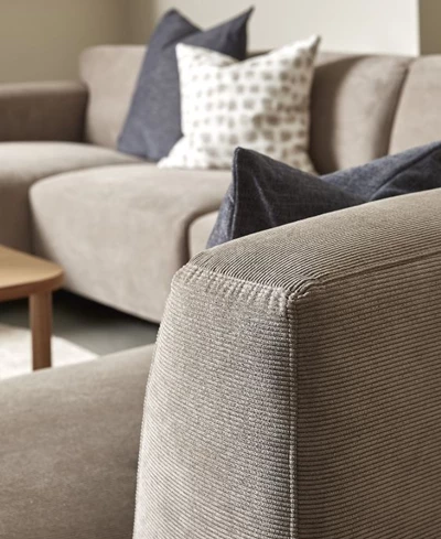 Närbild av armstöd på sandfärgad soffa