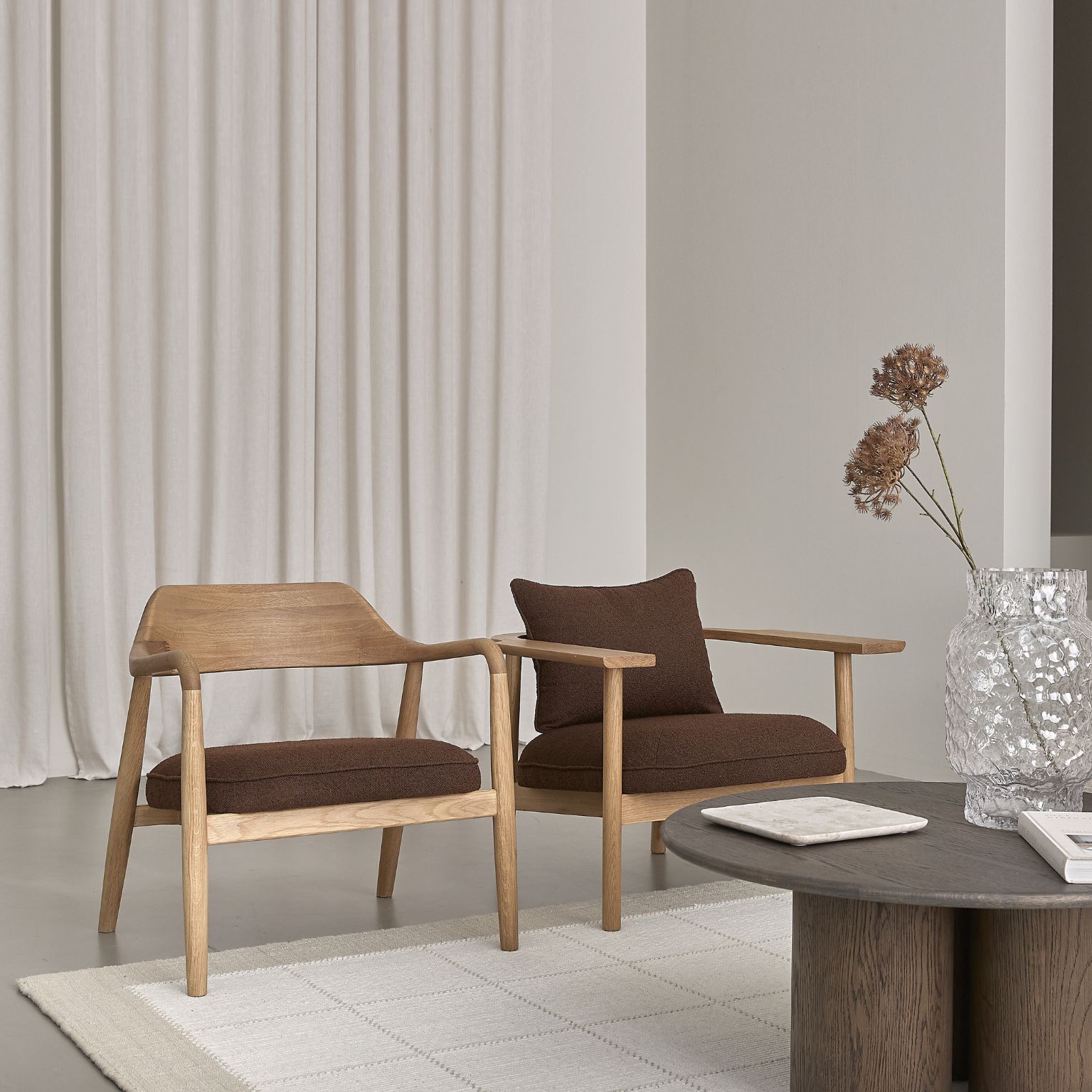 Två fåtöljer i trä med röd klädsel stående bredvid varandra